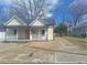 Charming bungalow featuring a cozy front porch, painted a warm neutral color under a blue sky at 614 Oak St, Burlington, NC 27215