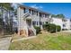Two-story townhouse featuring light siding, dark shutters, a brick foundation, and landscaped yard at 6221 Tributary Dr, Raleigh, NC 27609