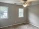 A bedroom features carpet flooring and neutral paint, enhanced by natural light from two windows at 6225 Tributary Dr, Raleigh, NC 27609