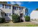 A well maintained multi-Gathering unit with neutral siding, black shutters, and green bushes at 6225 Tributary Dr, Raleigh, NC 27609