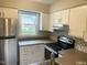 The stainless steel refrigerator adds to this kitchen with white cabinets and gray countertops at 6225 Tributary Dr, Raleigh, NC 27609