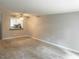 Spacious living room with neutral walls, plush carpet, and connecting window to kitchen at 6225 Tributary Dr, Raleigh, NC 27609