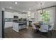 Modern kitchen with white cabinets, stainless steel appliances, and adjacent dining area at 69 White Azalea Way, Homesite 81, Benson, NC 27504