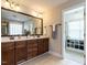 This bathroom features a double sink vanity, granite countertops, and tile flooring with a large mirror and walk-in closet at 730 Toms Creek Rd, Cary, NC 27519