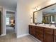 Well-lit bathroom with a double vanity, tiled floor, and shower with glass enclosure at 730 Toms Creek Rd, Cary, NC 27519