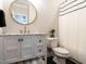 Stylish bathroom with a round mirror, black and white accents, and modern fixtures at 730 Toms Creek Rd, Cary, NC 27519