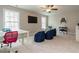 This bedroom features carpet floors, a ceiling fan, large windows, and a dedicated gaming space at 730 Toms Creek Rd, Cary, NC 27519