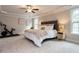 Spacious bedroom with tray ceilings, a ceiling fan, and a large comfortable bed at 730 Toms Creek Rd, Cary, NC 27519