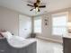 This bedroom features carpet floors, a ceiling fan, and ample natural light from a pair of large windows at 730 Toms Creek Rd, Cary, NC 27519