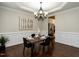Elegant dining room with chandelier, wainscoting, and wood flooring at 730 Toms Creek Rd, Cary, NC 27519