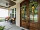 Charming front porch with elegant wooden front doors and cozy seating at 730 Toms Creek Rd, Cary, NC 27519