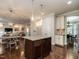 Open-concept kitchen featuring a granite island with pendant lighting and hardwood floors at 730 Toms Creek Rd, Cary, NC 27519
