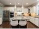Modern kitchen with a large granite island, stainless steel appliances, and pendant lighting at 730 Toms Creek Rd, Cary, NC 27519
