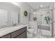 Modern bathroom featuring a tiled shower with a glass door, granite countertop, and ample lighting at 74 Powderhorn Pt, Garner, NC 27529
