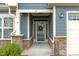 Close-up of entryway with decorative door, stone supports, and well-manicured landscaping at 74 Powderhorn Pt, Garner, NC 27529