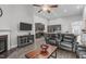 Open concept living room with a fireplace, television, wood floors, and view into the kitchen at 74 Powderhorn Pt, Garner, NC 27529