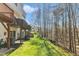 The backyard features a well-maintained lawn, wooded area, and exterior access at 8415 Reedy Ridge Ln, Raleigh, NC 27613