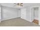 Spacious bedroom with neutral carpet, fan and light, with double doors to a bathroom at 8415 Reedy Ridge Ln, Raleigh, NC 27613