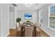 Bright dining room with wood floors, seating for six, and large windows at 8415 Reedy Ridge Ln, Raleigh, NC 27613