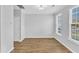Bright and spacious empty room featuring neutral walls, hardwood floors, and ample natural light at 8415 Reedy Ridge Ln, Raleigh, NC 27613