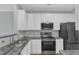 Kitchen features stainless steel appliances, granite counters and white cabinets at 8415 Reedy Ridge Ln, Raleigh, NC 27613