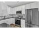 Modern kitchen featuring stainless steel appliances, white cabinets, and tile backsplash at 8415 Reedy Ridge Ln, Raleigh, NC 27613