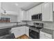 Modern kitchen with stainless steel appliances, white cabinets and granite countertops at 8415 Reedy Ridge Ln, Raleigh, NC 27613