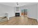 A modern living room with a fireplace, sliding glass door with a view of a deck and wooded area at 8415 Reedy Ridge Ln, Raleigh, NC 27613