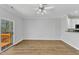 Open-concept living room with access to deck, ceiling fan, and luxury vinyl flooring at 8415 Reedy Ridge Ln, Raleigh, NC 27613
