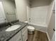 Full bathroom featuring a granite vanity, a tub-shower combo, and white fixtures for a clean design at 91 Lotus Ave, Smithfield, NC 27577