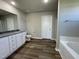 A neutral bathroom is equipped with double vanity, white cabinets, and wood-look flooring at 91 Lotus Ave, Smithfield, NC 27577