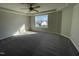 A bright bedroom features plush gray carpeting, a ceiling fan, and a large window at 91 Lotus Ave, Smithfield, NC 27577