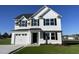 Charming two-story home with white siding, black shutters, well-manicured lawn, and an attached garage at 91 Lotus Ave, Smithfield, NC 27577