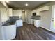 Modern kitchen with white cabinets, granite countertops, stainless steel appliances, and wood-look flooring at 91 Lotus Ave, Smithfield, NC 27577