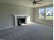 Spacious living room featuring neutral carpet, a fireplace with a mantle, and abundant natural light from two windows at 91 Lotus Ave, Smithfield, NC 27577