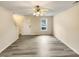 An empty, freshly painted living room with hardwood floors, a ceiling fan, and a window at 910 Savin Lndg, Knightdale, NC 27545