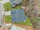 Aerial view of a home with a dark roof, green grass, and surrounding trees at 112 Pointe Park Cir, Holly Springs, NC 27540