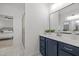 Bathroom featuring a vanity with a mirror with a glimpse into an adjacent bedroom with white walls at 112 Pointe Park Cir, Holly Springs, NC 27540