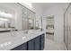 Bathroom featuring a white quartz countertop with double mirrors and a glimpse into an adjacent bedroom at 112 Pointe Park Cir, Holly Springs, NC 27540