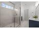 Bright bathroom featuring a glass-enclosed shower with white marble tiles, and blue vanity with white marble floors at 112 Pointe Park Cir, Holly Springs, NC 27540