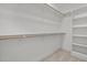 A white walk-in closet featuring wooden racks and shelves with carpet floors and white walls at 112 Pointe Park Cir, Holly Springs, NC 27540