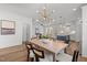 Open dining room with stylish chandelier, wood table, and seamless flow into the modern kitchen at 112 Pointe Park Cir, Holly Springs, NC 27540