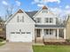 Charming two-story home features a welcoming front porch and a two-car garage at 112 Pointe Park Cir, Holly Springs, NC 27540