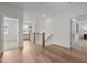 Upstairs hallway featuring hardwood floors and multiple doorways to carpeted bedrooms at 112 Pointe Park Cir, Holly Springs, NC 27540