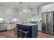 Bright kitchen boasts a center island with seating, stainless appliances and pendant lights at 112 Pointe Park Cir, Holly Springs, NC 27540