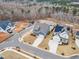 Aerial view of a blue home featuring landscaping, a driveway, and proximity to lush woodlands at 112 Sire Ct, Holly Springs, NC 27540
