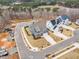 An aerial view of a blue home featuring landscaping, a driveway, and proximity to lush woodlands at 112 Sire Ct, Holly Springs, NC 27540