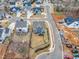 Aerial view of a blue home featuring landscaping, a driveway, and proximity to lush woodlands at 112 Sire Ct, Holly Springs, NC 27540