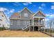 View of a charming gray two-story home with a screened porch and a well-maintained, fenced backyard at 112 Sire Ct, Holly Springs, NC 27540