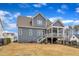 View of a charming gray two-story home with a screened porch and a well-maintained, fenced backyard at 112 Sire Ct, Holly Springs, NC 27540
